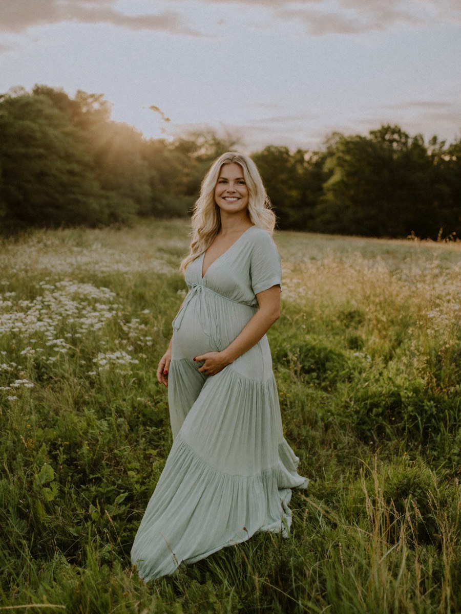 A maternity portrait in a wildflower meadow at sunset